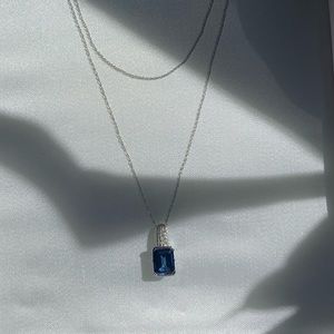 Sapphire pendant necklace with pink sapphire side accents on white gold necklace